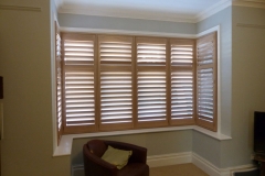 Natural Wood Shutters In Square Bay in Living Room