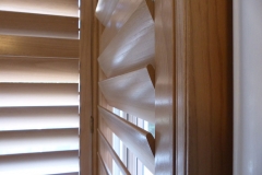 Close Up of Louvre Blades of Natural Wood Shutters in Square Bay Window