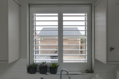 White Plantation Shutters with 89mm Louvres Fitted to Window Above the Kitchen Sink