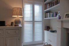 White Plantation Shutters with Middle Rail Fitted to Patio Doors In Lounge
