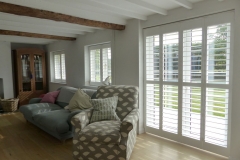 Living Room with White Plantation Shutters Fitted on the Windows and Patio Doors