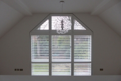 Tall Shaped Window with Custom Made White Shutters Fitted