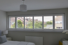 White TPost Shutters Fitted to Wide Window in Bedroom