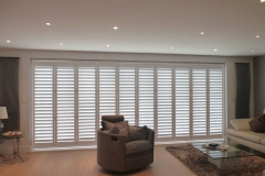 Tracked Shutters Across Wide Doors in Living Room