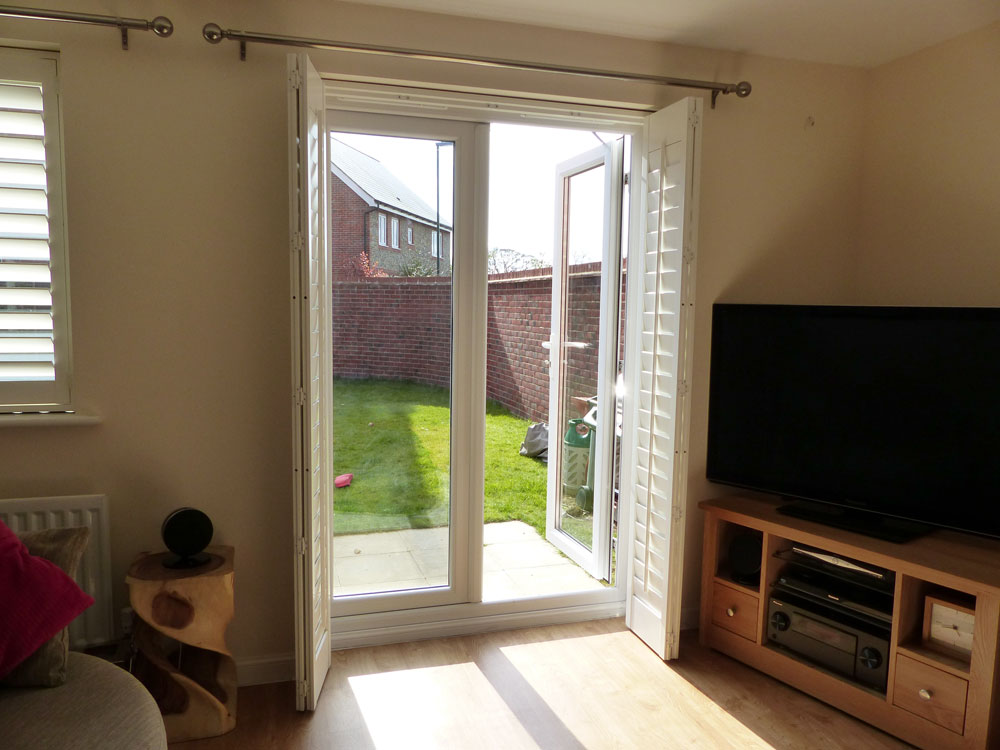 Bi-folding shutters across a door Bi-folding shutters across a door