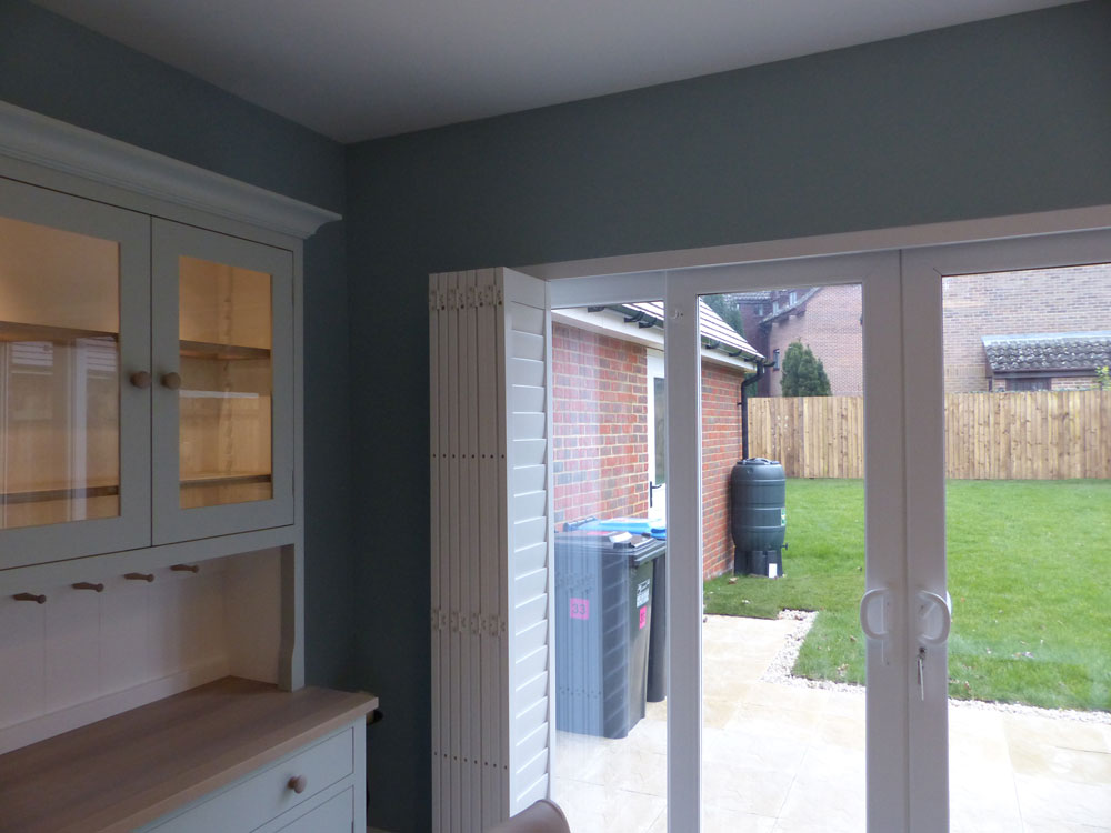 Tracked Bi-Folding Shutters Pushed to Left Side of Wide Patio Doors Tracked Bi-Folding Shutters Pushed to Left Side of Wide Patio Doors