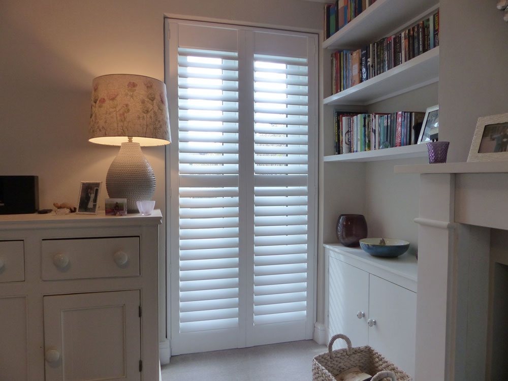 White Plantation Shutters with Middle Rail Fitted to Patio Doors In Lounge
