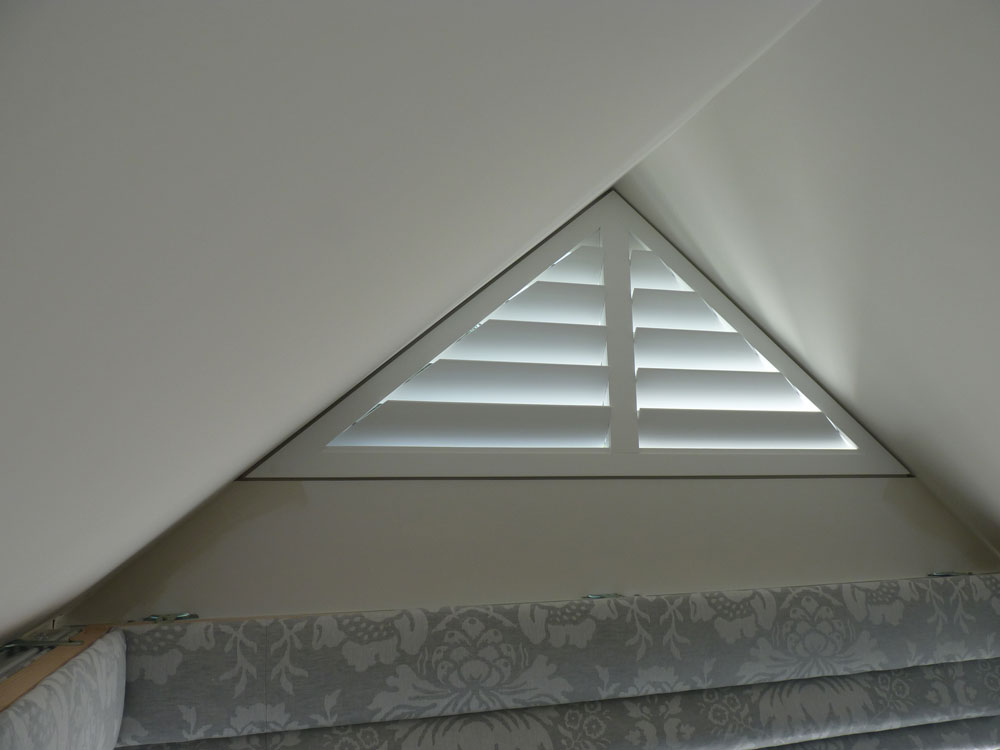 Small Triangle Shape Window with White Wooden Shutters