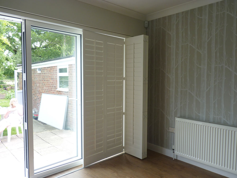 Track Mounted Shutters Partially Closed Over Patio Doors