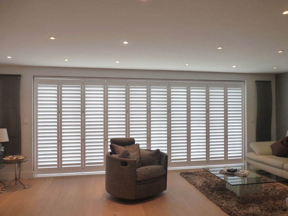 White Tracked Shutters on Wide Patio Doors in Living Room